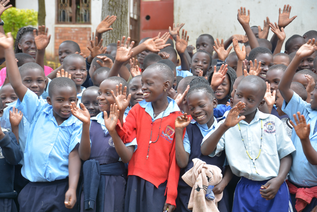 Schoolchildren waving and smiling