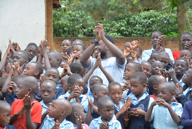 Children clapping together with a volunteer